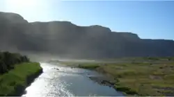 Die Oranjerivier vanaf die skeidingsbrug tussen Noordoewer en Vioolsdrif. Uiterste hitte en sonlig veroorsaak sigbare verdamping.