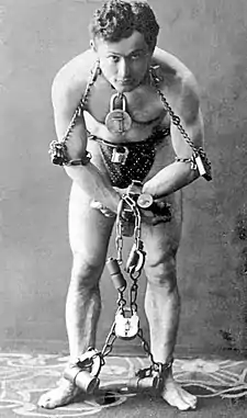 O prestidichitador Harry Houdini en 1899 mientres d'una d'as suyas actuacions.