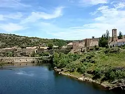 O río Lozoya en Buitrago del Lozoya, con o puent viello de Buitrago del Lozoya y as murallas d'a localidat