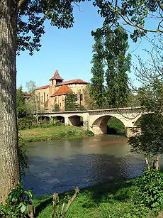 Puent sobre o río Arros en Sent Sever, con o monesterio de Sent Sever