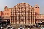 A large palace in red and pink sandstone with many windows