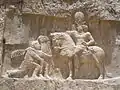 Rock-face relief at نقش رستم of Persian emperor سابور الأول (on horseback) capturing Roman emperors فاليريان (kneeling) and فيليب العربي (standing)