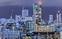 A cluster of modernist office buildings in at night.