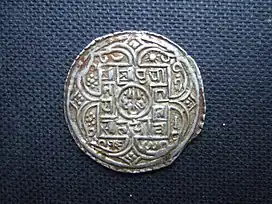 عملة المحار الفضية لبريتفي نارايان شاه, التي صُكت في عهد ساكا (Saka) عام 1685 (عام 1763 م) عندما كان ملكًا لباتان. (وجه العملة)