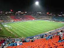 An all-seated roofless stadium with a football pitch.