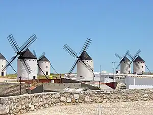 Molino de vientu nel Campo de Criptana, La Mancha. Teunoloxía d'orixe mediooriental, introducir n'España nel sieglu XVI, non muncho primero que los inmortalizara Cervantes. Tradición más antigua teníen los molinos d'agua.