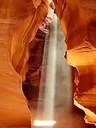 Rayos de lluz enfusando nun angostu pasadizo natural, Cañón del Antílope en Arizona.