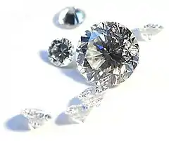 Seven clear faceted gems, six small stones of similar size and a large one.