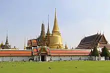 A Thai temple complex with several ornate buildings and a stupa, and a lot of visitors