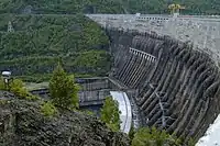 Luftseite der Staumauer mit der Hochwasserentlastung incl. Tosbecken im Hintergrund und den Fallleitungen und Maschinenhaus im Vordergrund