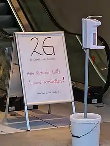 Schild mit 2G und Desinfektionsspender