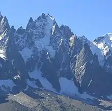 Frontalaufnahme auf den Aiguille du Plan mit dem Glacier du Plan in der Bildmittel, daneben die Nachbargipfel, im oberen Teil schneebedeckt; weiter unten blosser Fels, weniger steil