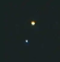 Albireo, fotografiert durch ein Teleskop mit 20 cm Öffnung. Die obere (orange) Komponente ist Albireo A, die untere (blaue) Albireo B.