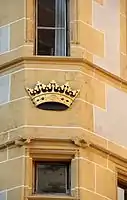 Detail mit Fenstergewänden und Gesimsen (2011). Die Krone ist eine Replikation. Das Original wurde vermutlich 1915 abgeschlagen.