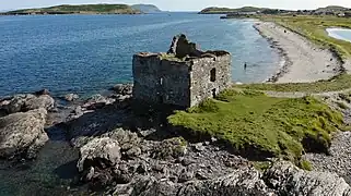 Luftaufnahme der Ruine des Tower Houses mit der Klosterruine im Hintergrund