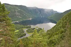 Blick auf einen See, an dessen Ufer das Terrain steil ansteigt