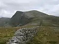 Blick über den Rücken des Diollaid a’ Mhill Bhric mit der Famine Wall zur breiten Gipfelkuppe des Beinn Dearg