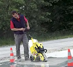 Straßenbauarbeiten mit Trennschleifer auf Führungswagen