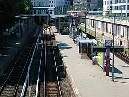 Der Bahnhof Hamburg-Blankenese
* im Vordergrund Gleise und Bahnsteige,
* links hinten das Empfangsgebäude mit den Treppenabgängen aus den 1980er Jahren,
* rechts Neubauten auf dem ehemaligen Güterbahnhof