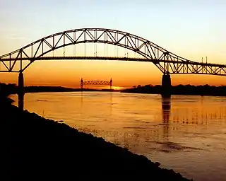 Die Bourne-Bridge über den Cape Cod Canal, mit der Cape Cod Canal Railroad Bridge im Hintergrund. Die Brücken befinden sich in der Nähe der Stadt Bourne in Barnstable County, Massachusetts. Es handelt sich um zwei der drei Brücken über den Cape Cod Canal.