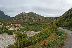 Am Fluss Kir mit dem Burghügel über dem Dorf in der Bildmitte