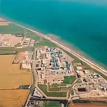 Aerial view of the gridiron arrangement of buildings and pipes beside the curving Yorkshire sea coast