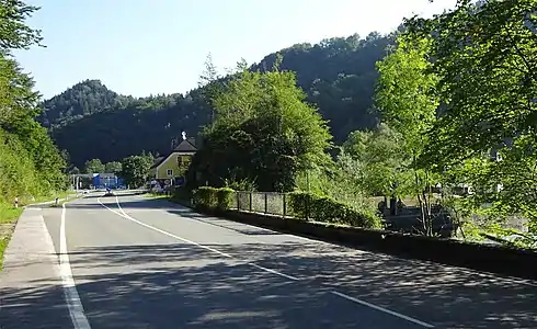 Felsenrest Hangender Stein s. Bildmitte vor ehemaligem österreichischem Zollhaus; rechts davon hinter den Blättern das Wehr des Almkanals; Blick in Richtung Salzburg