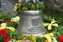 Glocke der Dreieinigkeit der Johanneskirche Schöndorf geschmückt mit Blumen