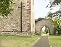 Bergfried mit Torbogen in der Trennmauer zur Hauptburg, Kreuz für Kriegsgefangene