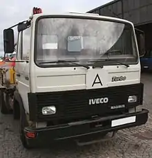 Photo eines parkenden LKW, an dem vorn außen ein A-Schild angebracht ist.