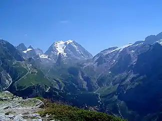 Blick von Westen über den Talkessel von Pralognan auf den Col de la Vanoise, mit der Aiguille de la Vanoise und der darüberstehenden Grande Casse. Rechts erhebt sich das Gebirge zum Gletscherdach der Glaciers de la Vanoise.