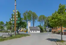 Das Foto zeigt Leimitz vor Ort: Links den Maibaum, in der Mitte die Feuerwehr