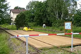 ehemaliges Bahnhofsgebäude (hinten) mit Draisinenstation Lustadt-Mitte im Vordergrund