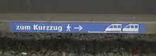 Dieser an einer Stromschiene der U-Bahn München angebrachte Aufkleber weist die Fahrgäste auf die Halteposition eines sogenannten Kurzzugs hin, der nur zwei Drittel der Bahnsteiglänge ausfüllt