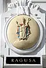 Das alte Wappen von Dubrovnik mit dem Stadtpatron St. Blasius  auf dem einst von der Marinesektion des k.u.k. Kriegsministeriums genutzten Amtsgebäude Marxergasse 2 in Wien. Im amtlichen Gebrauch der k.u.k. Marine wurden die Namen in italienischer Sprache verwendet.