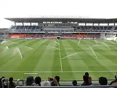 Blick auf die Haupttribüne mit laufender Bewässerungsanlage (März 2015)