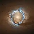 Ein Ring starker Stern­entstehung um das Galaxien­zentrum mit markanter Hα-Emission (blau, Falsch­farben­dar­stellung), auf­ge­nom­men mit­hilfe des Hubble-Weltraum­teleskops, 2004