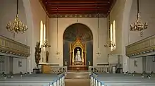 Blick aus Richtung Turmraum in das Kirchenschiff mit den Galerien in den Seitenschiffen und dem Altar mit dem Bild Jesus mit Kind (1873) von Carl Bloch