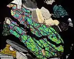 Olivin-Korn in einer mikroskopischen Dünnschliffaufnahme (gekreuzte Polarisatoren) des magmatischen Tiefengesteins Gabbro