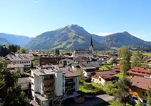 Kössen mit Pfarrkirche Hl. Petrus und Hl. Paulus und Unterberghorn im Hintergrund.