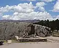 Halbkreisförmiger Platz mit erhöhtem Felsen bei Q'enqo Grande.