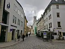 Menschen laufen auf einer Straße nahe des Markts in Weimar.