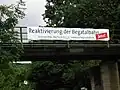 Reaktivierungsplakat an der B66-Brücke in Bega