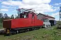 Zwei elektrische Lokomotiven („Ettan“ und „Femman“) und ein Personenwagen bei der Museumseisenbahn von Robertsfors., im Hintergrund das Mühlenmuseum