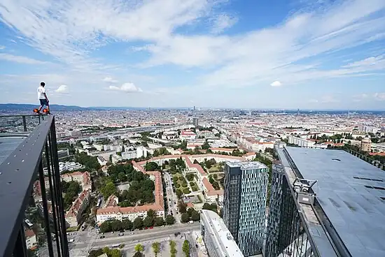 Ein Rooftopper steht an der Dachkante des höheren Twin Towers.