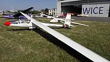 Ein SZD-42-2 Jantar 2B auf dem Vorfeld des Flugplatz Gliwice. Gut zu erkenne ist die zweigeteilte Haube, die bei vielen früheren Segelflugzeugen aufgrund von erhofften Strömungsvorteilen benutzt wurde.