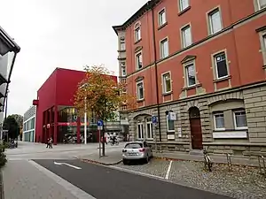 Schrammstraße/Ecke Sattlerstraße heute: Die dunkelrote Ecke der Stadtgalerie liegt an der einstigen, nordöstlichen Ecke des Werks