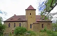 Ansicht von Süden mit romanischem Portal und barocken Sarkophagen