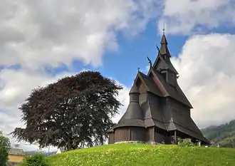 Foto einer reich verzierten Holzkirche, die auf einer Anhöhe steht