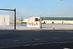 Großes weißes Schild mit den roten „TESLA“-Buchstaben